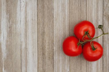 Yıpranmış ahşap arka plan üzerinde kırmızı asma olgun domates