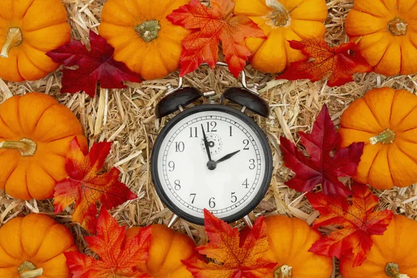 Es tiempo de otoño con despertador y calabazas de color naranja y caída le — Foto de Stock