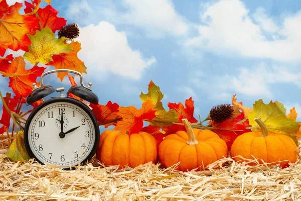 Őszi jelenet ébresztőórával és narancs sütőtök és ősz le — Stock Fotó