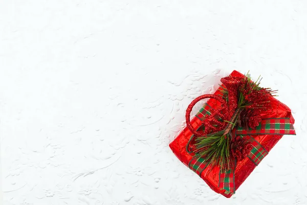 Röd julklapp med kottar och horn på en silverbakdel — Stockfoto