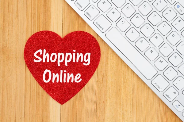 Amor compras en línea con un corazón de purpurina roja con un teclado —  Fotos de Stock