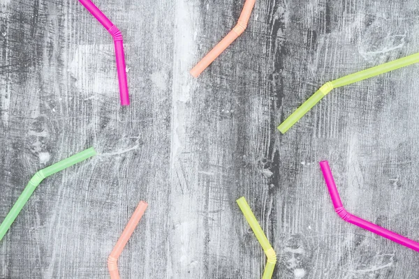 Multi gekleurde plastic rietjes op zwarte grunge achtergrond — Stockfoto