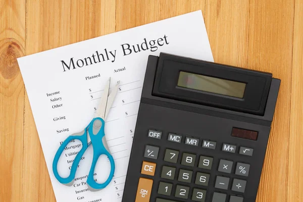 Cutting your monthly budget with a calculator and scissors — ストック写真