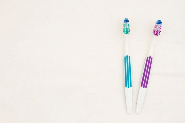 Two toothbrushes on a white towel background — Stok fotoğraf