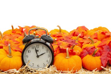 Çalar saat turuncu balkabaklarıyla samanların üzerinde saman var. Mesajınız için kopyalama alanı var.