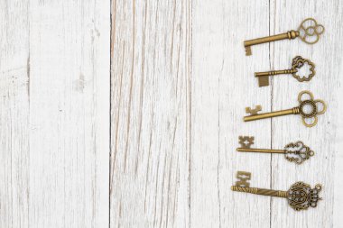 Yıpranmış ahşap zemin üzerinde iskelet anahtarlar ve güvenlik veya kilit mesajı için kopyalama alanı ile tahıl dokusu