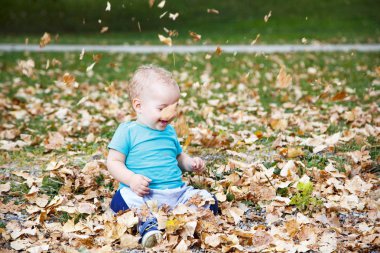 Sonbahar içinde yaprakları ile oynayan bebek çocuk
