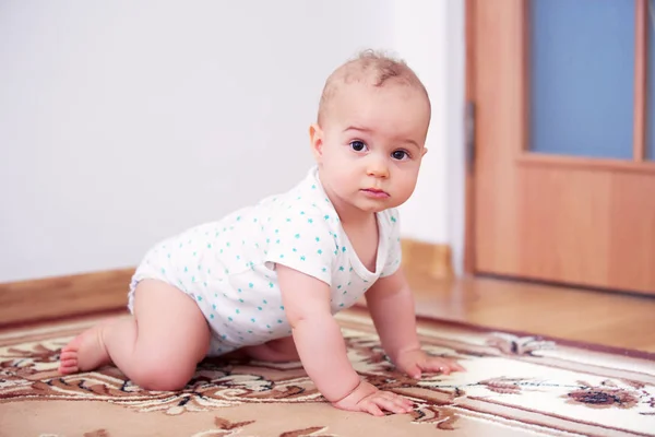 Happy baby boy playing on floor in children 's room — стоковое фото