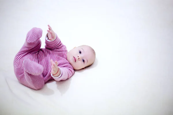 Schönes Kind, das mit den Beinen auf dem Bett im Schlafzimmer spielt — Stockfoto