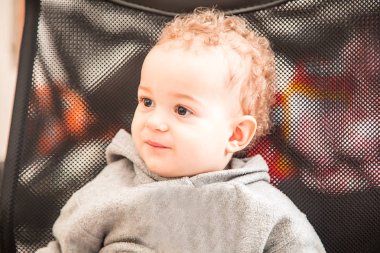 Çok güzel bir yaşında küçük çocuk portre bir sandalyede oturuyor