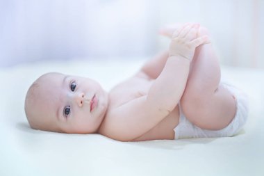 Mutlu çocuk bezi güneşli bir yatak odasında oynarken