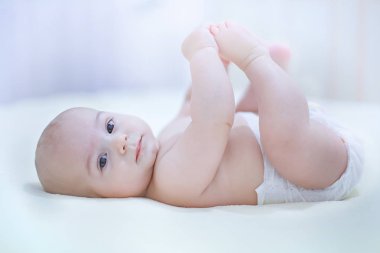 Güneşli bir kreş ayaklarıyla oynayan sevimli çocuk