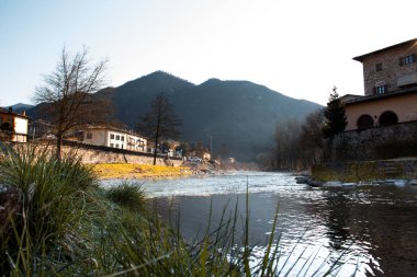 Şafak vakti nehirde gün doğarken çimlerin üzerinde çiy taneleri vardı..