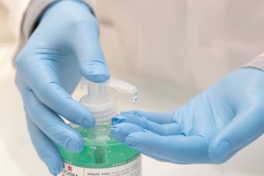 Brescia, İtalya, 10 Nisan 2020. Eldivenli doktor elleri dezenfekte eder. Covid-19 karantinasını tamamlamak için sağlık standartlarına saygı