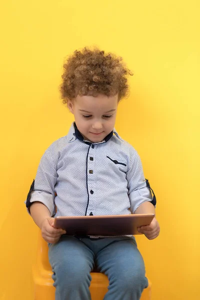 Niño sonriente mirando tableta digital y jugando juegos en línea — Foto de Stock