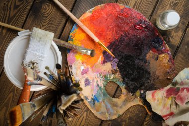 Boyalar, fırçalar, palet koyu ahşap arka plan