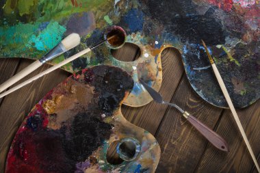 Boyalar, fırçalar, palet koyu ahşap arka plan