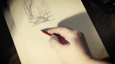 Adam bir kalem kağıt üzerinde çizer..