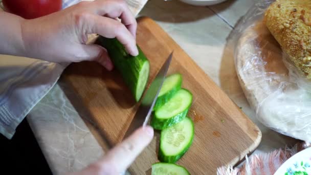 Frau in der Küche schneidet Gurken und Tomaten — Stockvideo