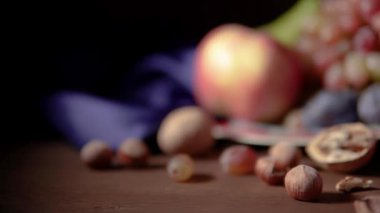 Meyve ve kırmızı şarapla dolu bir hayat. Üzüm, elma, armut, erik, fındık ve mavi kumaş.