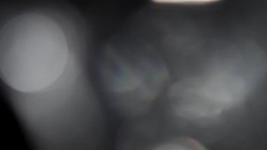 Hareket eden bokeh, sönmüş, bulanık, siyah arkaplanda yanıp sönen ışık
