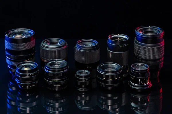 Vintage and modern lenses for the camera on a black background — Stock Photo, Image