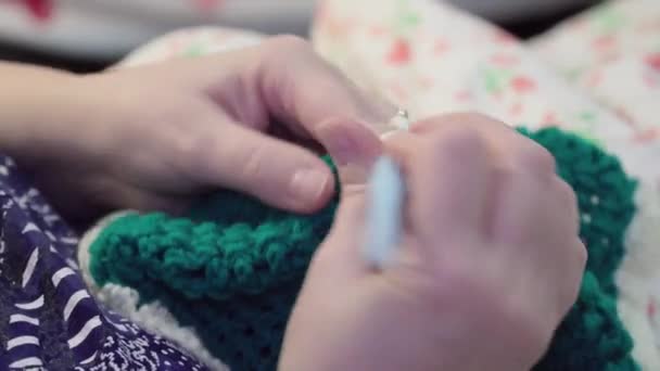 白と緑の毛糸を編む女性の手のクローズアップ — ストック動画