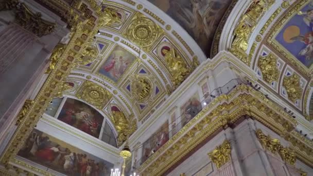 Saint-Pétersbourg, Russie - 24 février 2020 : Cathédrale Saint-Isaacs, bel intérieur, peintures murales, sculptures, moulures en stuc. Les touristes marchent, regardent et prennent des photos . — Video