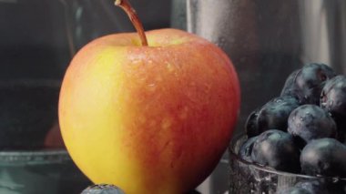 Koyu arkaplanda yabanmersini, elma ve bardaklar