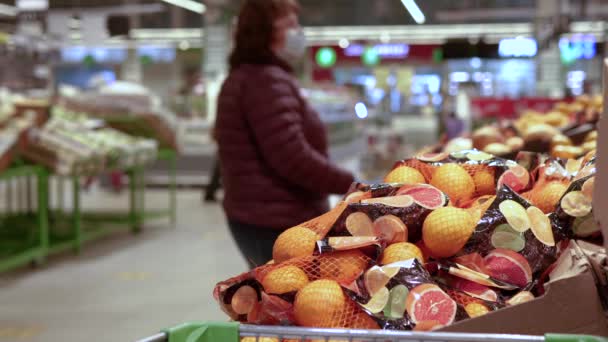 As pessoas em máscaras médicas escolhem produtos no supermercado — Vídeo de Stock