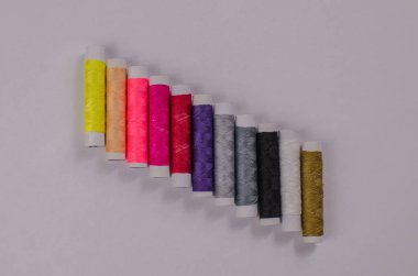 Makaralı çok renkli iplikler, dikiş seti, arka planda terzi seti. Beyaz arkaplan