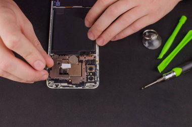 Siyah arka planda akıllı telefon tamiri. Kırık bir ekranın değiştirilmesi