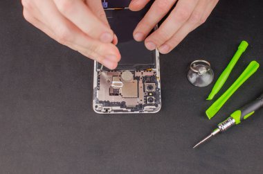 Siyah arka planda akıllı telefon tamiri. Kırık bir ekranın değiştirilmesi