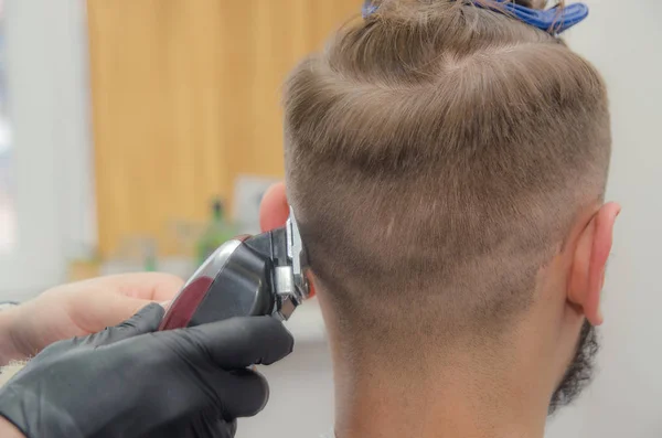 Männlicher Haarschnitt auf weißem Hintergrund. männlicher Friseur. — Stockfoto