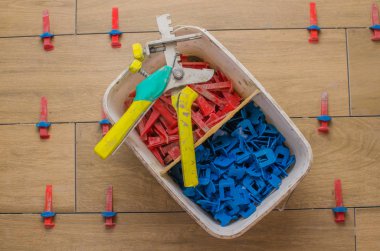 New tile floor home renovation project, large format ceramic tiles with wood texture, plastic levelers and a notched trowel for mortar.