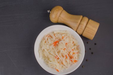sauerkraut and carrots in a plate. horizontal view from above, rustic style. Fermented food. Copy space.