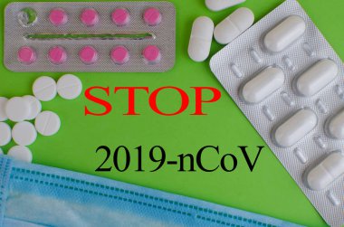 Text phrase Coronavirus on a green background with medicines and protective masks. Novel coronavirus 2019-nCoV.