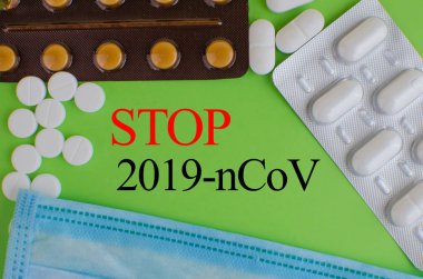 Text phrase Coronavirus on a green background with medicines and protective masks. Novel coronavirus 2019-nCoV.