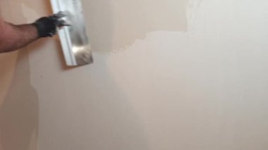 İşçi macunu duvarlara koyar. Eşit, sıva.