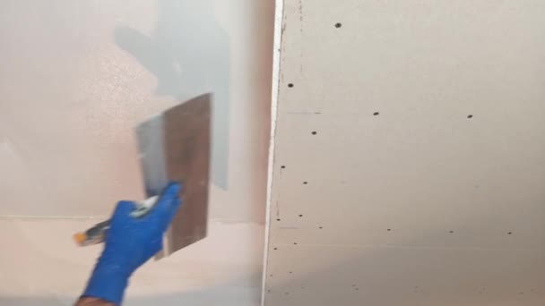 工人把油灰贴在墙上.它是相等的，它是斑斑的 — 图库视频影像