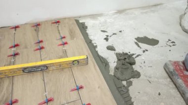 Yapıştırıcı yapıştırıcı sürüyor ve fayansları yerleştiriyor.