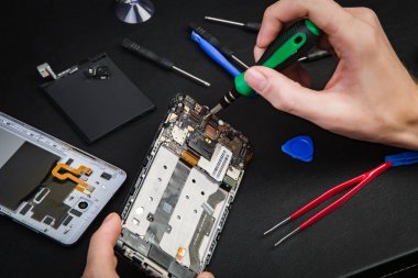 Kırık telefon tamiri süreci. Demonte smartphone ve özel aletler.