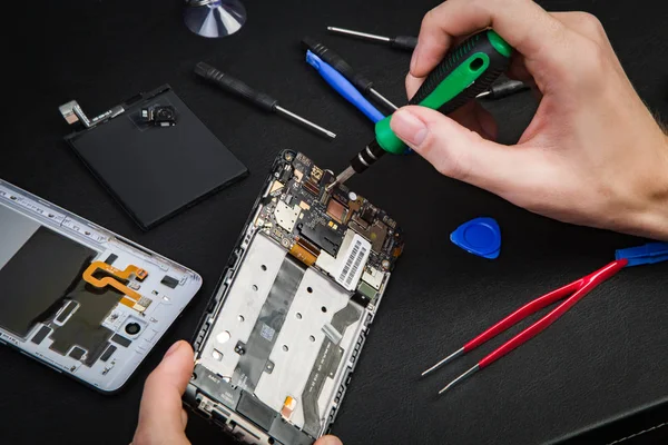 Kırık telefon tamiri süreci. Demonte smartphone ve özel aletler.