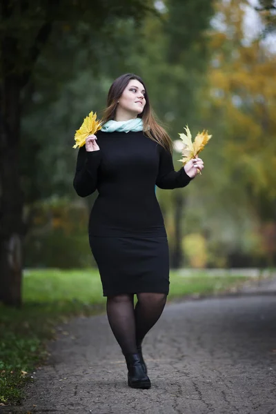 Jovem bonito caucasiano plus size modelo em vestido preto ao ar livre, mulher xxl na natureza, atmosfera de outono — Fotografia de Stock