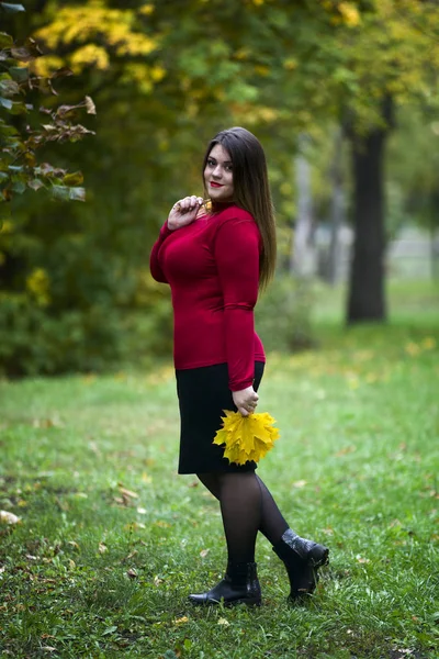 Jonge mooie Kaukasische plus grootte model in rode trui buitenshuis, xxl vrouw op natuur, herfst sfeer — Stockfoto