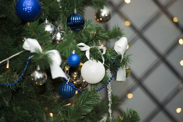 Brillante palla bianca di Natale appesa su rami di pino con sfondo festivo — Foto Stock