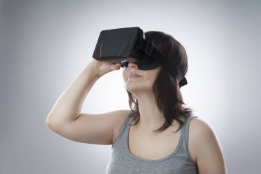 Genç bir kadın sanal gerçeklik gözlüğü kullanıyor.