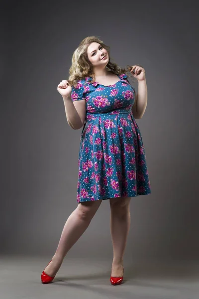 Junge schöne blonde plus size model in kleid und schuhe, xxl frau auf grauem studio-hintergrund — Stockfoto