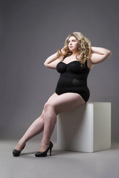 Junge schöne Blondine plus Size-Modell in Shapewear, XL-Frau in schlanker Unterwäsche auf grauem Studiohintergrund — Stockfoto