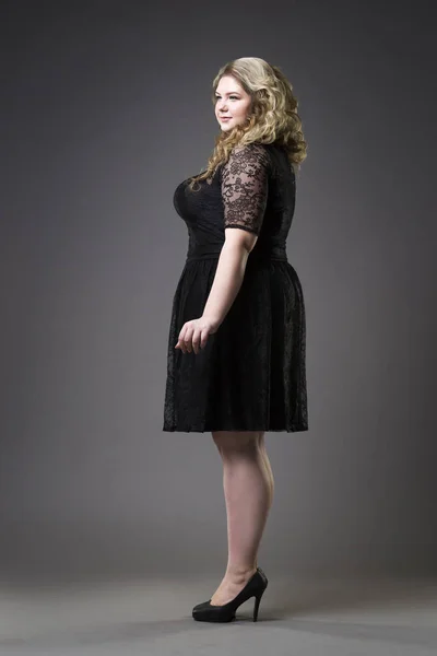 Joven modelo hermoso más tamaño en negro dres, xxl mujer en gris fondo de estudio —  Fotos de Stock